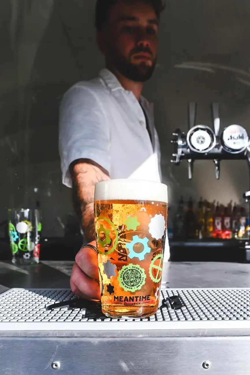 Bartender handing over a freshly poured pint